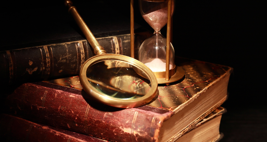 Old books with a magnifying glass and hourglass